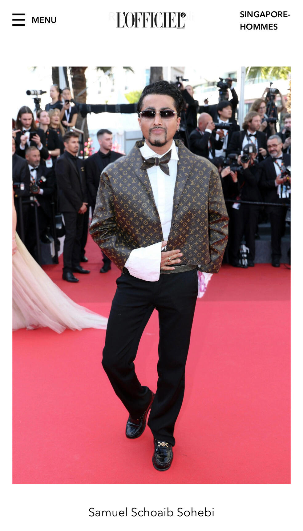 Samuel Sohebi on the red carpet at the Cannes Film Festival 2025, featured in L’Officiel Hommes Singapore, wearing a Louis Vuitton look with patterned jacket and bow tie.